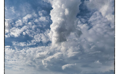 Clouds towering over green prairie